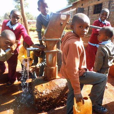 Students drawing Water from Repaired pump