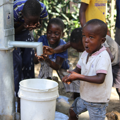 Children around the new pump enjoying safe water!