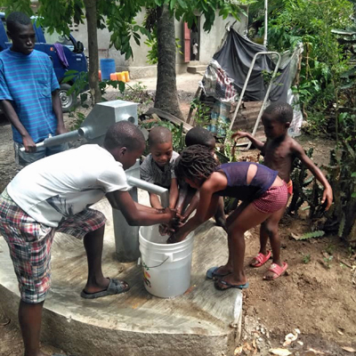 Excited children drinking water from the new well!