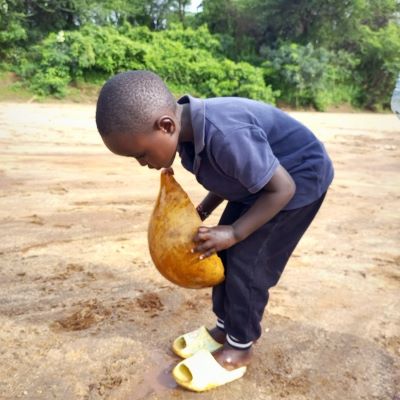 Village kid standing on a dry river bed