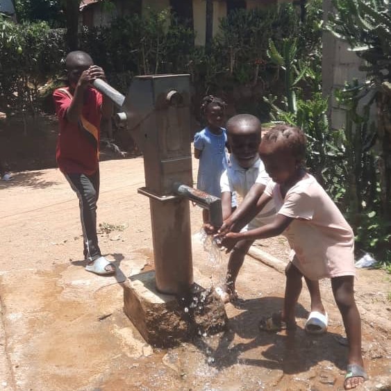 Children by the newly repaired pump