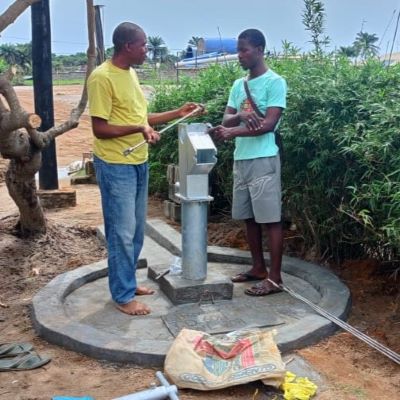 Staff installing a new hand pump on a new communal well 