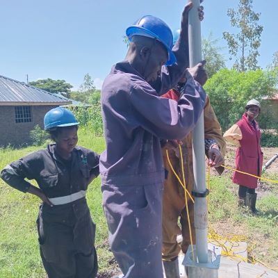 The team installing a hand pump on a new well