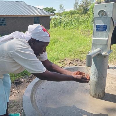 Villager washing hand from the new well