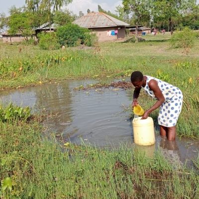 A villager collecting water from a swamp