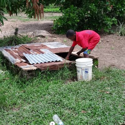 Villager collecting water from an old water source 