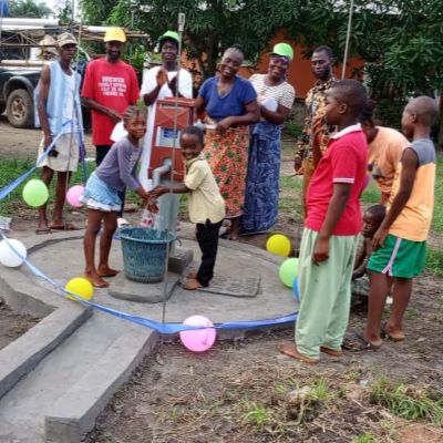 Happy villagers alongside their communal well