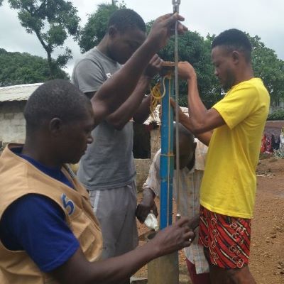Hand pump repair team working to restore the flow of clean water