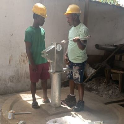 The team installing hand pump on the new well