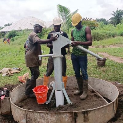 Team installing hand pump on the new well