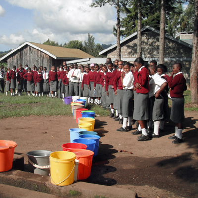 Students lining up to get daily water from repaired pump