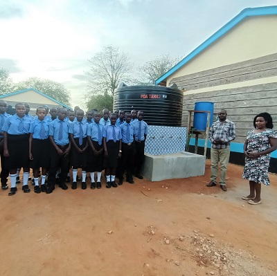 Students, teachers alongside the new tank and handwashing station