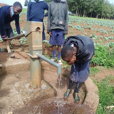 This young students enjoys clean water after years of going without it when the pump broke down 
