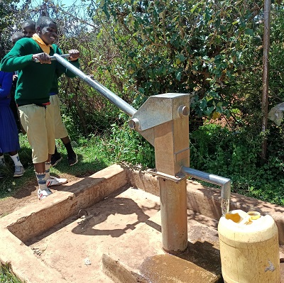 Students pumps water after a well-done job on the broken pump 