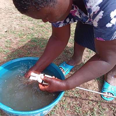 A community member happy to help in the repair of the pump