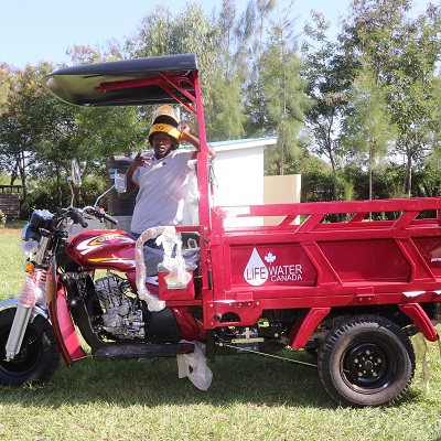 Stada's team member posing for a picture a long side the new vehicle 