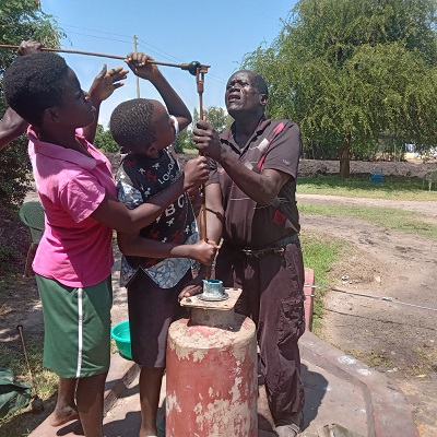 Pump repair team joined by young community members to repair the pump