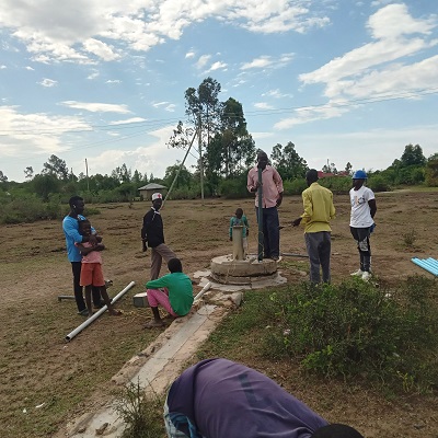 Kolal community members watching rehabilitation of the damaged pump 