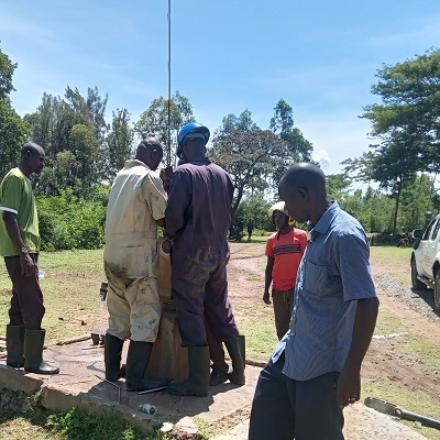 The team working on the broken hand-pump 