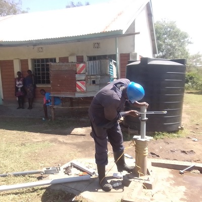 Pump repair team working on a broken hand-pump 