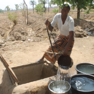 Woman fetching from community well 