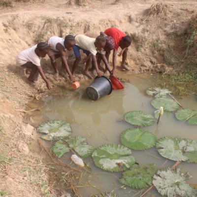 Children fetching from the dirty community pond