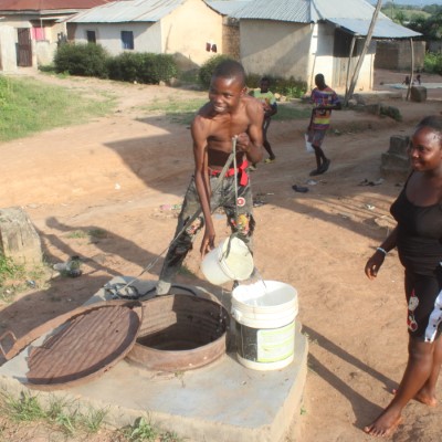 Teenage boy fetching from community well 