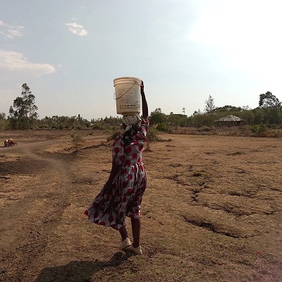 A villager carrying home clean and safe water from the hand-pump