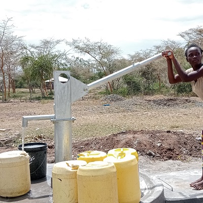 Woman pumping water from the source of clean water 