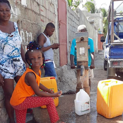 Child drawing water from newly repaired well